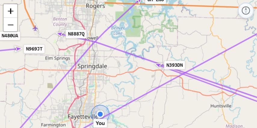 Live flight tracker showing aircraft positions, trails, and ownership data over a map